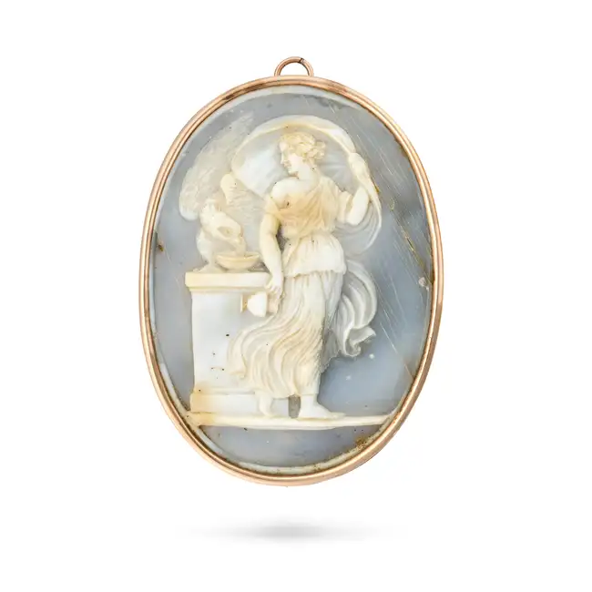 AN ANTIQUE AGATE CAMEO BROOCH / PENDANT set with an oval agate cameo depicting the goddess Hebe
