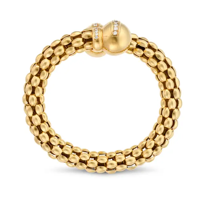A LARGE DIAMOND BANGLE in crossover design, the tubular bangle comprising rows of fancy links,