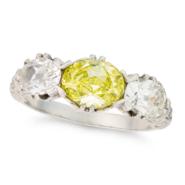 A FANCY VIVID YELLOW GREEN AND WHITE DIAMOND RING set with an oval cut yellow green diamond of