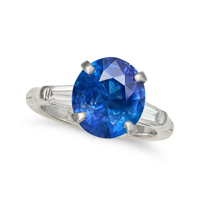 A SAPPHIRE AND DIAMOND THREE STONE RING set with an oval cut sapphire of approximately 4.71