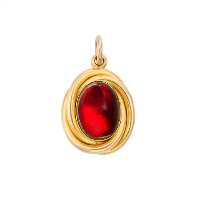 AN ANTIQUE VICTORIAN GARNET LOCKET PENDANT set with an oval cabochon garnet within a scrolling