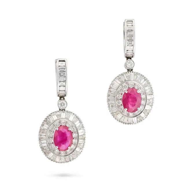 A PAIR OF RUBY AND DIAMOND DROP EARRINGS each suspending a drop set with an oval cut ruby in a