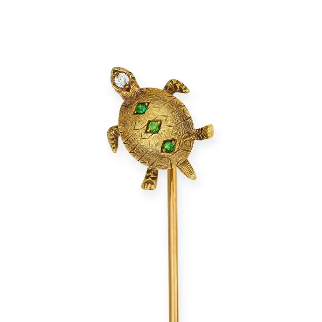 AN ANTIQUE TSAVORITE GARNET AND DIAMOND TURTLE STICK / TIE PIN designed as a turtle, the shell set