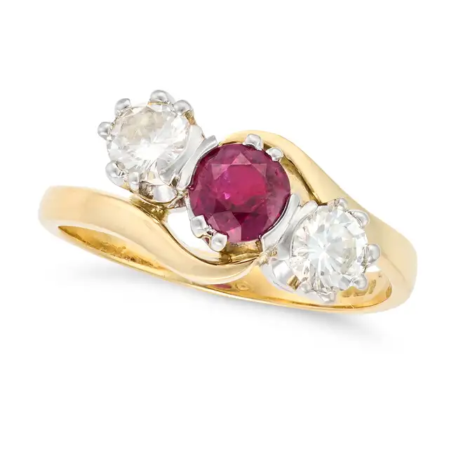 NO RESERVE - A RUBY AND DIAMOND THREE STONE RING in 18ct yellow gold, set with a cushion cut ruby of