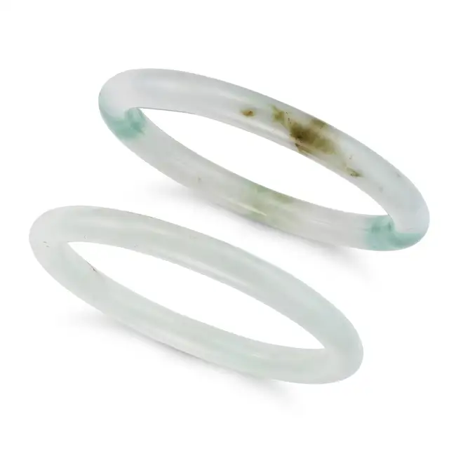 TWO JADEITE JADE BANGLES each comprising a single hoop of polished jadeite jade, each inner