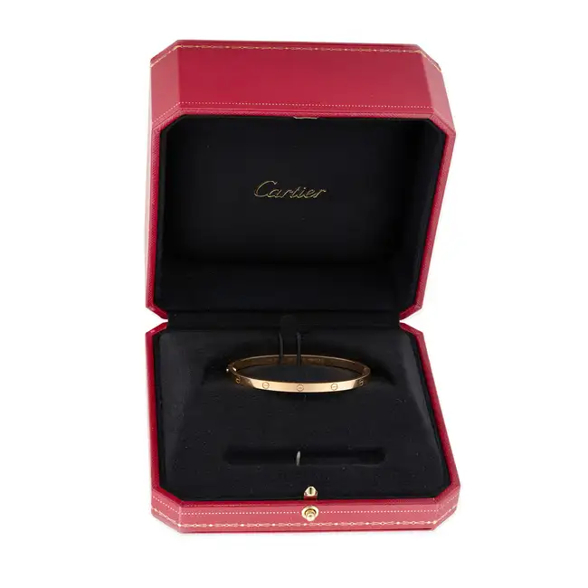 CARTIER, A SMALL MODEL LOVE BANGLE in 18ct rose gold, the hinged bangle punctuated by ten screw head
