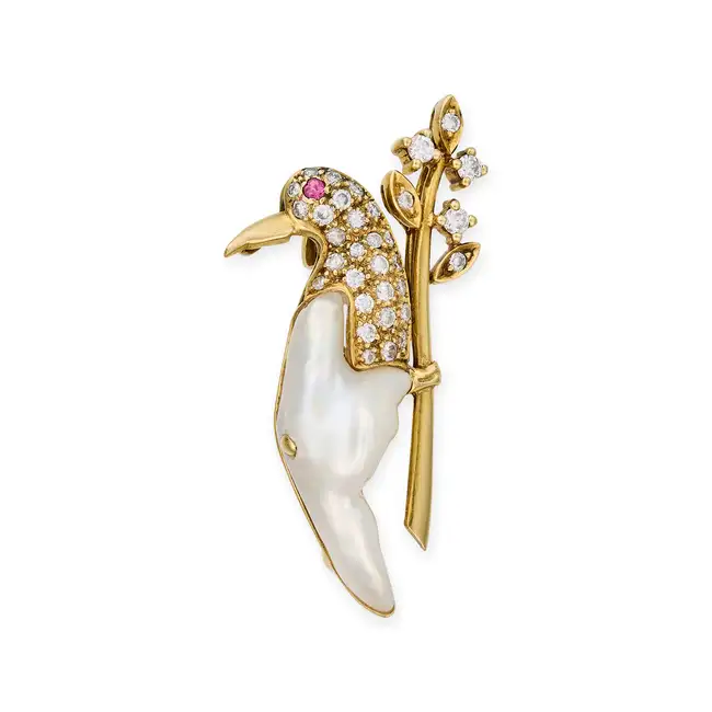 A BAROQUE PEARL, DIAMOND AND RUBY BIRD BROOCH designed as a bird perched on a branch, the bird