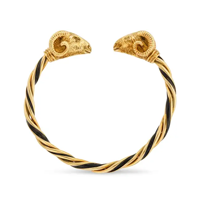 A VINTAGE ENAMEL RAM BANGLE in 18ct yellow gold, the open cuff bangle in twisted design, relieved in