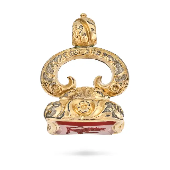 AN ANTIQUE CARNELIAN FOB SEAL / PENDANT the scrolling foliate style pendant set with a carnelian