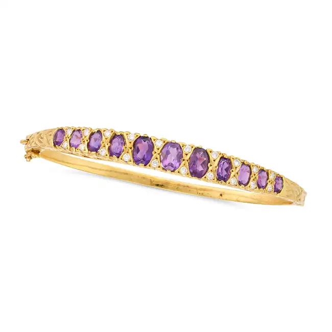 AN AMETHYST AND DIAMOND BANGLE the hinged bangle set with a row of graduating oval cut amethysts,