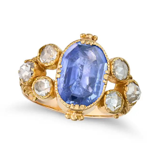 AN ANTIQUE CEYLON NO HEAT SAPPHIRE AND DIAMOND RING in yellow gold, set with cushion cut sapphire of