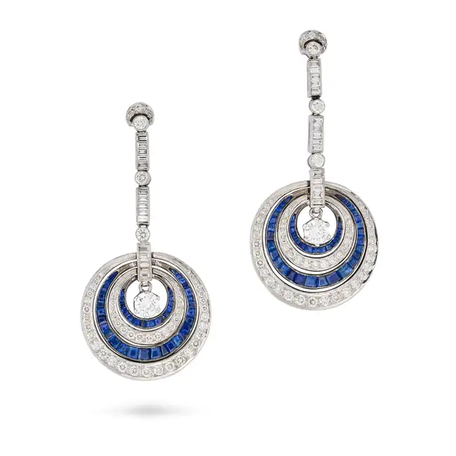 A PAIR OF DIAMOND AND SAPPHIRE DROP EARRINGS each suspending a round brilliant cut diamond within