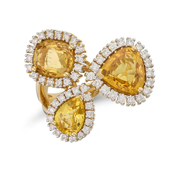 A YELLOW SAPPHIRE AND DIAMOND DRESS RING set with three variously cut yellow sapphires in borders of