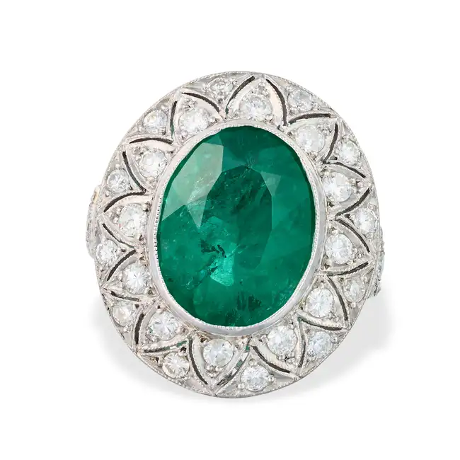 AN EMERALD AND DIAMOND RING set with an oval cut emerald of approximately 3.96 carats, the pierced