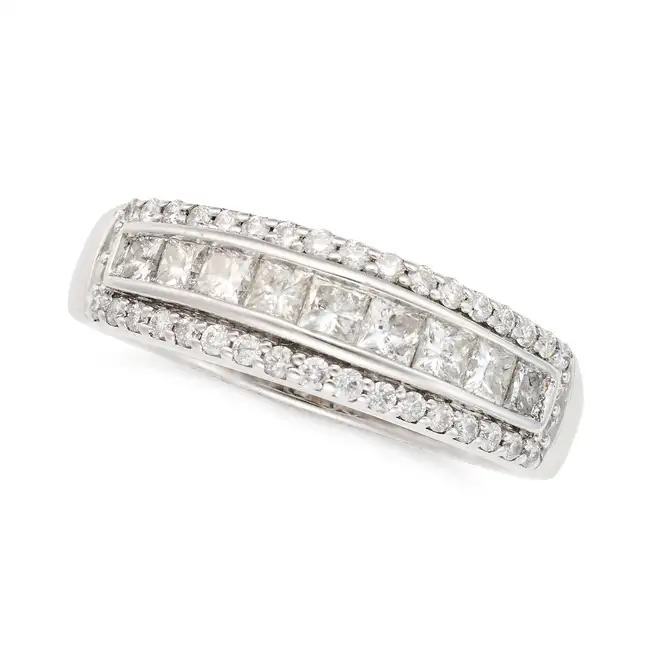 A DIAMOND BAND RING in 18ct white gold, set with a graduating row of princess cut diamonds, within a