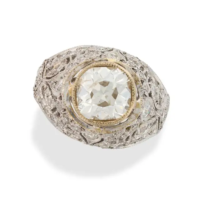 A DIAMOND BOMBE RING set with an old cut diamond of approximately 2.10 carats, the pierced mount set