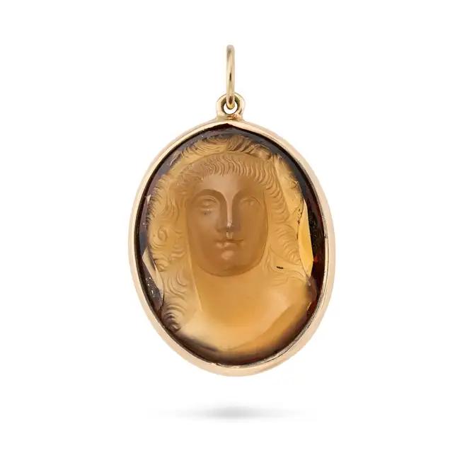 A SMOKY QUARTZ CAMEO PENDANT comprising a smoky quartz cameo carved to depict the bust of a