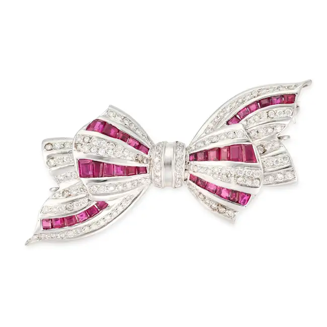 A RUBY AND DIAMOND BOW BROOCH / CLASP designed as a bow set with square cut rubies and round