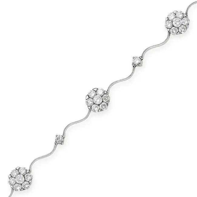A DIAMOND BRACELET comprising clusters of round brilliant cut diamonds and round brilliant cut