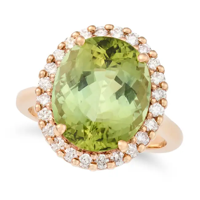 A GREEN TOURMALINE AND DIAMOND CLUSTER RING in 14ct yellow gold, set with an oval cut green