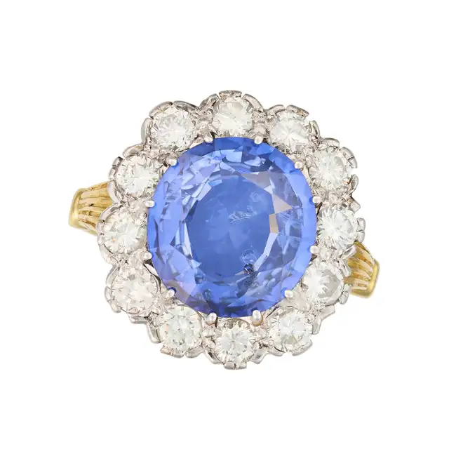 A FINE SAPPHIRE AND DIAMOND CLUSTER RING set with an oval cut sapphire of 6.23 carats in a cluster