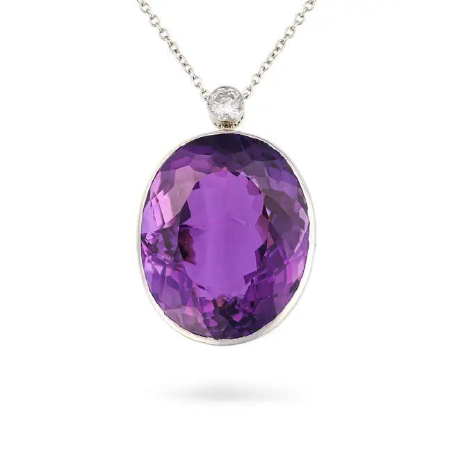 AN AMETHYST AND DIAMOND PENDANT NECKLACE the pendant suspending an oval cut amethyst of