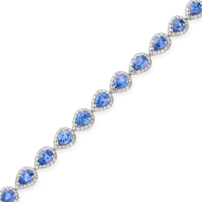 A CEYLON SAPPHIRE AND DIAMOND BRACELET set with a row of pear cut sapphires in borders of round