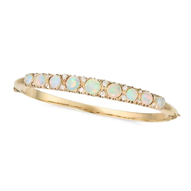 A FINE ANTIQUE OPAL AND DIAMOND BANGLE in yellow gold, the hinged bangle set to one half with a