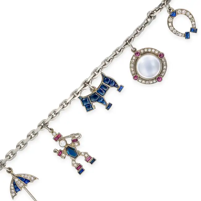 A FINE SAPPHIRE, RUBY, GARNET, MOONSTONE, ONYX AND DIAMOND CHARM BRACELET comprising a trace chain