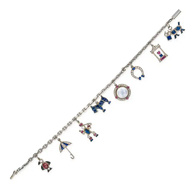 A FINE SAPPHIRE, RUBY, GARNET, MOONSTONE, ONYX AND DIAMOND CHARM BRACELET comprising a trace chain