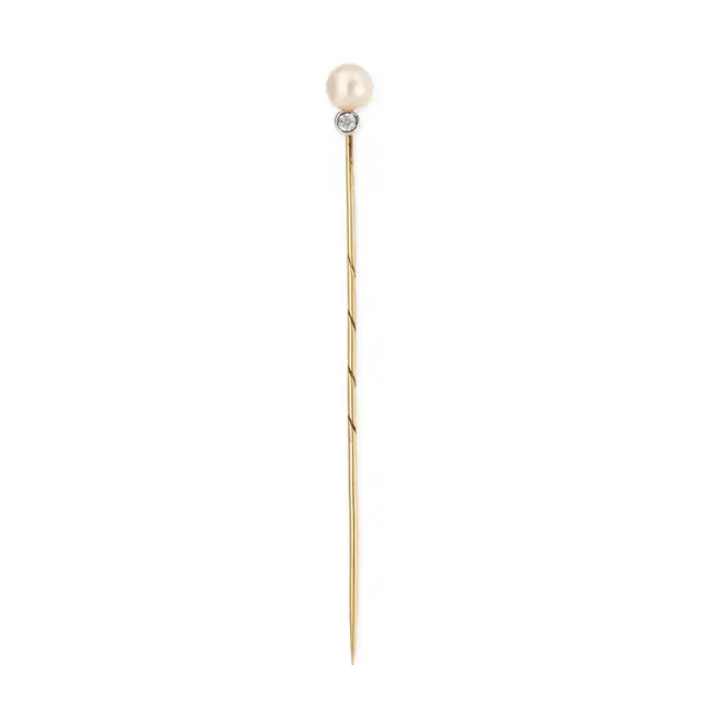 AN ANTIQUE AUSTRIAN PEARL AND DIAMOND STICK / TIE PIN in yellow gold, set with a pearl accented by