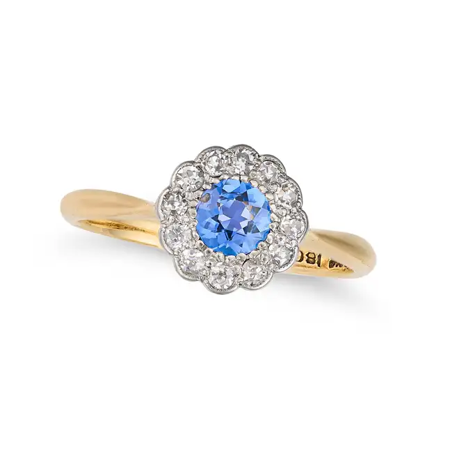 AN ANTIQUE SAPPHIRE AND DIAMOND CLUSTER RING in 18ct yellow gold, set with a round cut sapphire in a