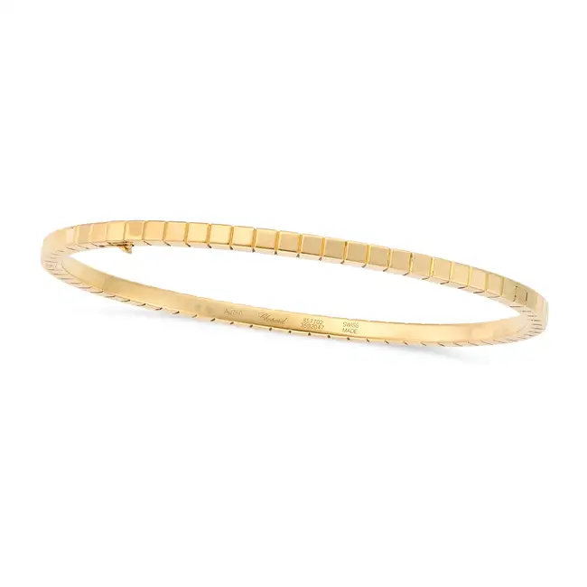CHOPARD, A GOLD ICE CUBE BANGLE in 18ct yellow gold, designed as a row of stylised ice cubes, signed