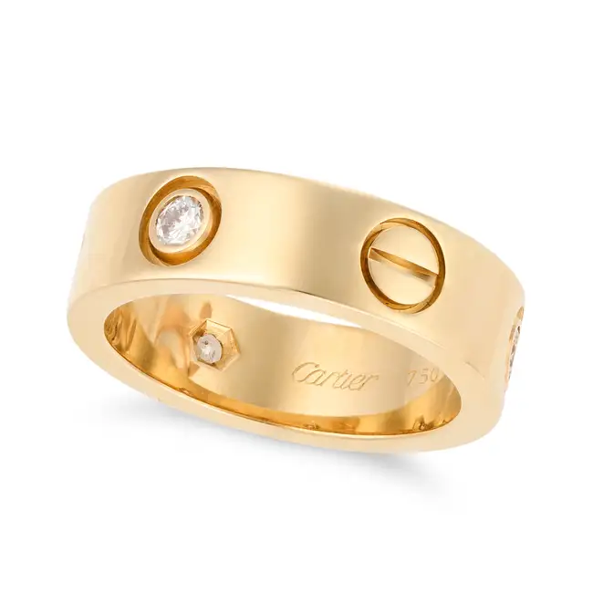 CARTIER, A DIAMOND LOVE RING in 18ct yellow gold, punctuated by screw head motifs and set with three