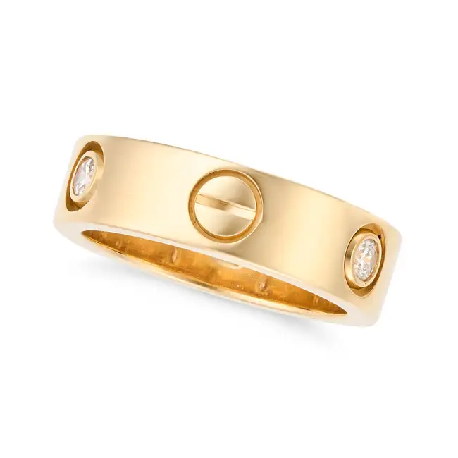 CARTIER, A DIAMOND LOVE RING in 18ct yellow gold, punctuated by screw head motifs and set with three