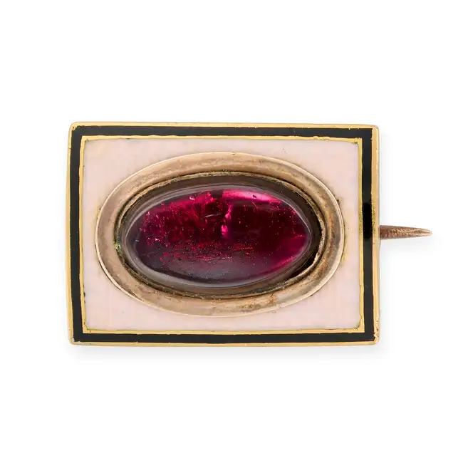 AN ANTIQUE GEORGIAN GARNET AND ENAMEL MOURNING BROOCH, 1804 set with an oval cabochon garnet, over a