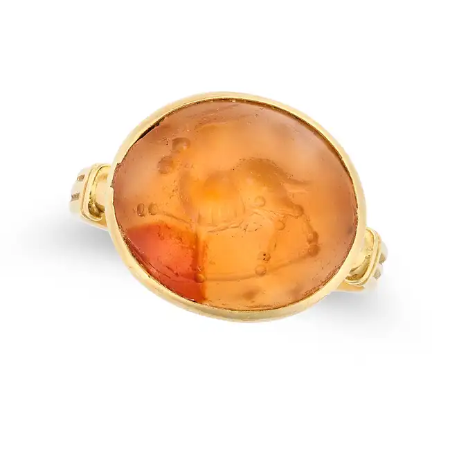 AN ANTIQUE CARNELIAN INTAGLIO RING in yellow gold, set with a carnelian intaglio carved to depict
