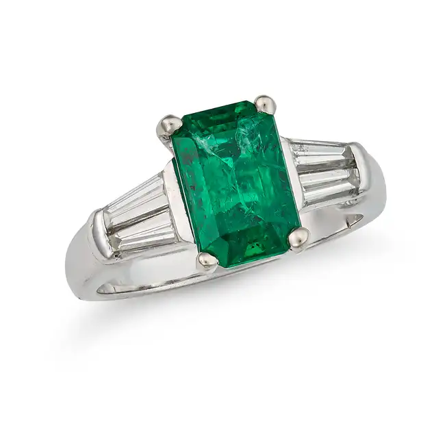AN EMERALD AND DIAMOND DRESS RING set with an octagonal step cut emerald of approximately 2.24