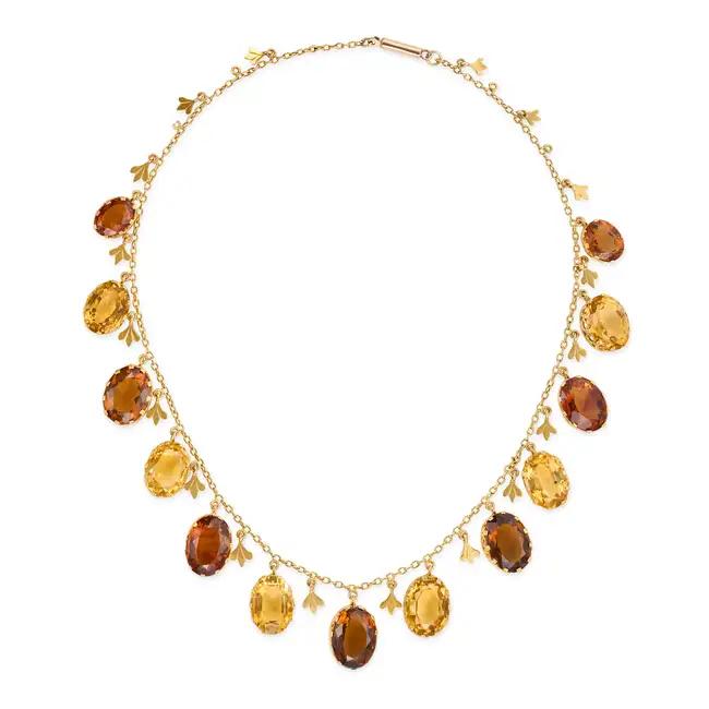 AN ANTIQUE CITRINE FRINGE NECKLACE comprising a trace suspending a fringe of oval cut citrines and