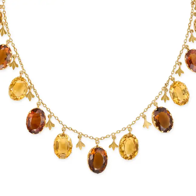 AN ANTIQUE CITRINE FRINGE NECKLACE comprising a trace suspending a fringe of oval cut citrines and