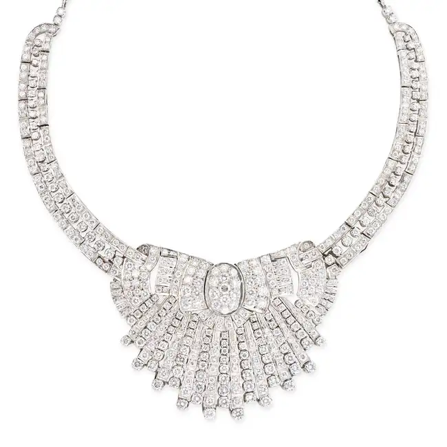 A DIAMOND COLLAR NECKLACE in silver, the stylised scrolling necklace set throughout with round
