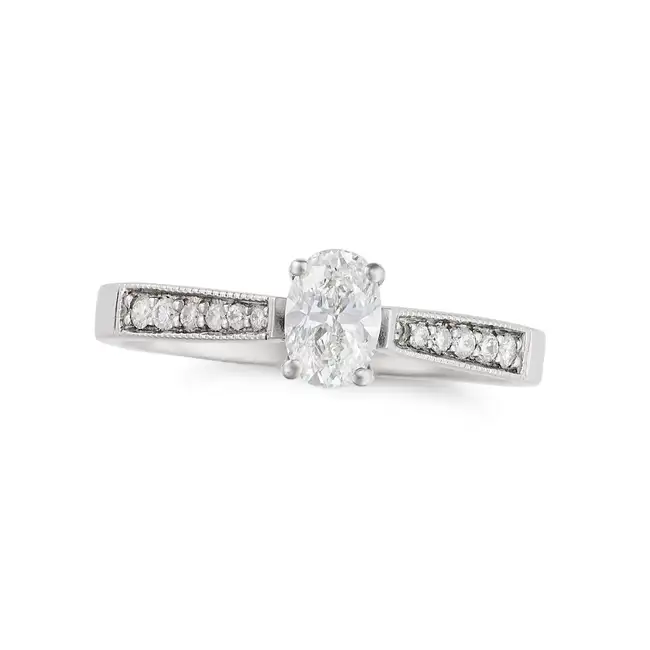 A SOLITAIRE DIAMOND RING in platinum, set with an oval cut diamond of 0.50 carats, the shoulders set