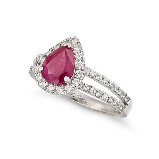 A BURMESE RUBY AND DIAMOND RING set with a pear cut ruby of 1.68 carats in a halo of round brilliant