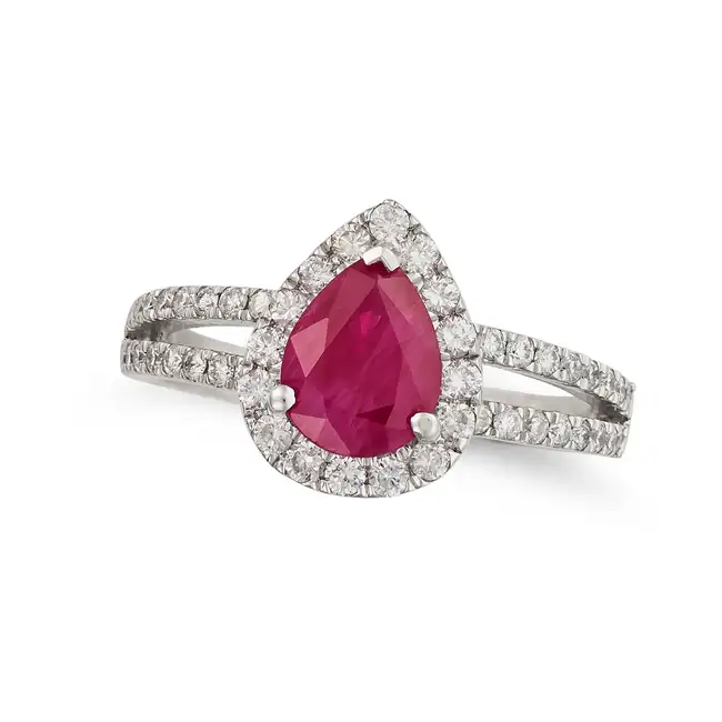 A BURMESE RUBY AND DIAMOND RING set with a pear cut ruby of 1.68 carats in a halo of round brilliant