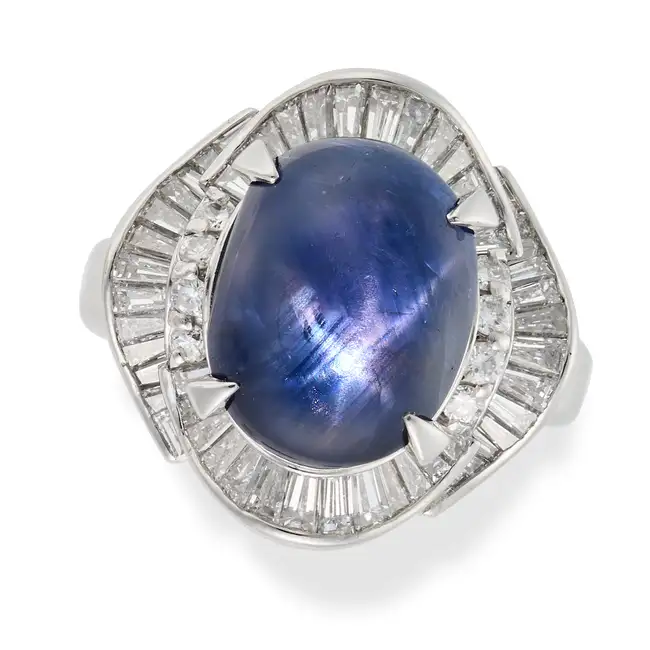 NO RESERVE - AN 8.29 CARAT STAR SAPPHIRE AND DIAMOND BALLERINA RING set with an oval cabochon star