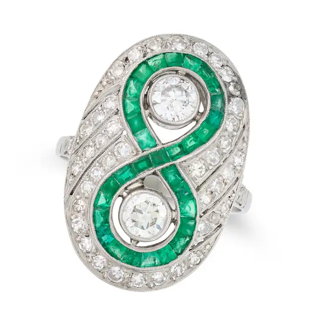 A FINE DIAMOND AND EMERALD DRESS RING in platinum, set with two old European cut diamonds, within