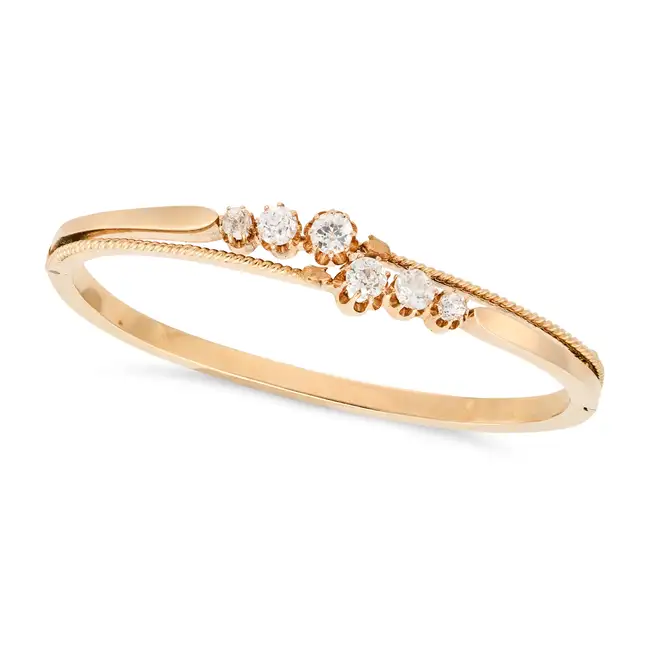 AN ANTIQUE DIAMOND BANGLE in yellow gold, the hinged bangle set with graduating rows of old cut