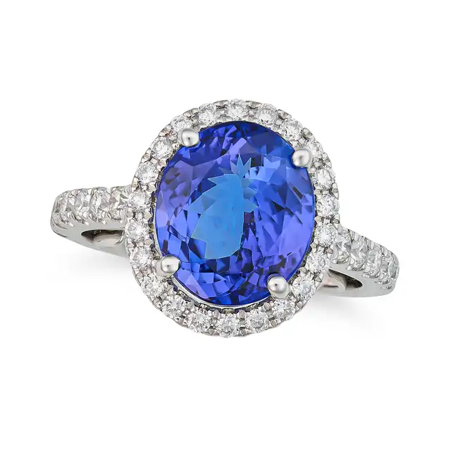 A FINE TANZANITE AND DIAMOND HALO RING set with an oval cut tanzanite of approximately 3.47