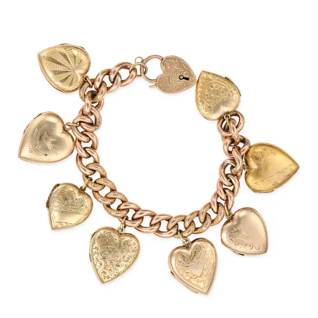 AN ANTIQUE GOLD HEART LOCKET CHARM BRACELET in yellow and rose gold, comprising a curb chain