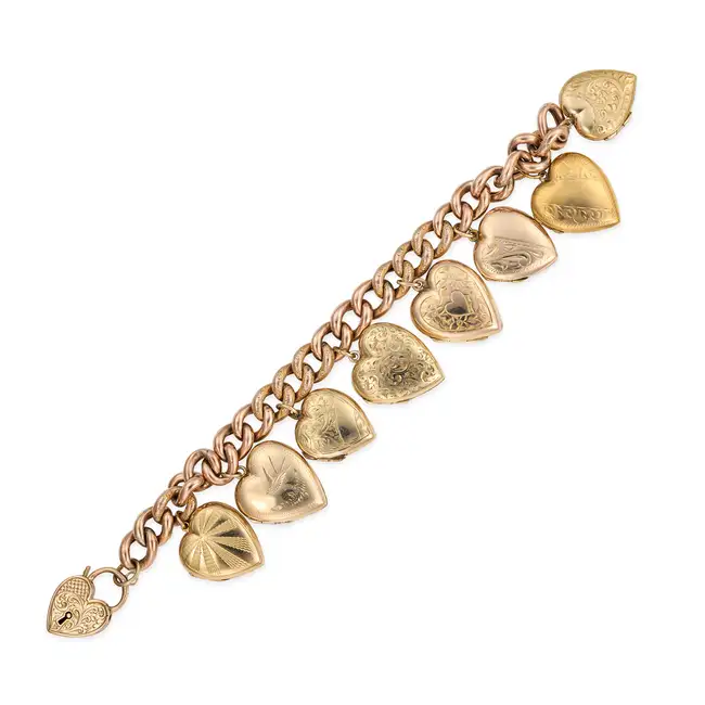 AN ANTIQUE GOLD HEART LOCKET CHARM BRACELET in yellow and rose gold, comprising a curb chain